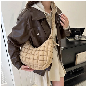 Detail of khaki quilted shoulder bag showing the soft puffer texture and knot strap design