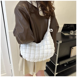 Detail of white quilted puffy moon bag showing fabric texture and square stitch pattern