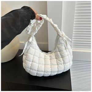 Detail of white quilted cloud shoulder bag with minimalist square puffed texture