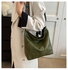 Detail of soft olive green hobo bag with ethnic embroidery wide shoulder strap