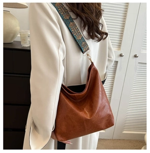 Detail of soft brown leather tote with vintage embroidered wide strap and gold hardware