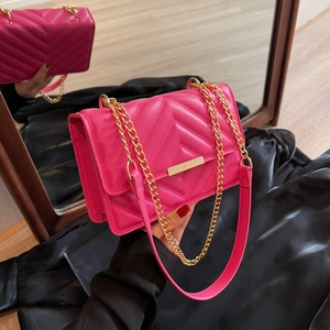 Fuchsia quilted crossbody bag with gold chain strap and metallic clasp closure