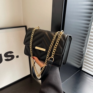 Vintage black quilted shoulder bag with gold chain strap and metallic lock closure