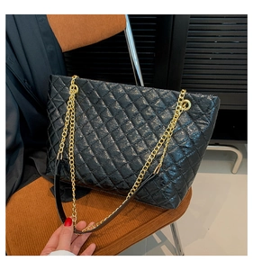 Détail du sac cabas matelassé noir avec finition brillante et chaîne dorée