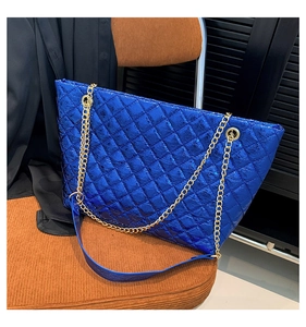 Détail du sac cabas bleu vif matelassé avec chaîne dorée et finition métallique