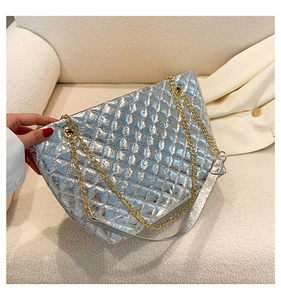 Détails du sac cabas matelassé argenté avec bandoulières en chaîne dorée et broderie