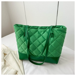 Close-up of green quilted tote bag with diamond stitching and smooth bottom detail