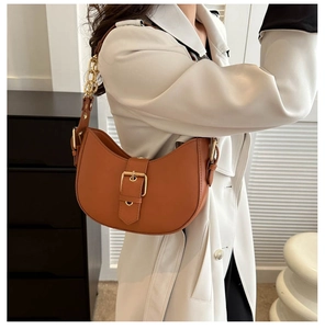 Detail of caramel crescent hobo bag with gold hardware and stylish chain shoulder strap