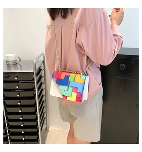 Detailed view of white crossbody bag with colorful Tetris-style patterns and gold chain