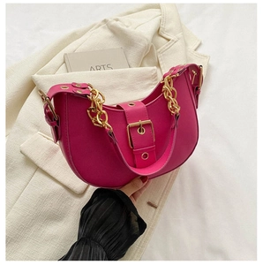 Detail of rose red crescent hobo bag featuring gold chain and oversized buckle closure
