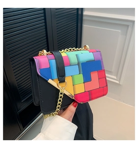Detail of colorful geometric patchwork flap with gold chain and metal buckle