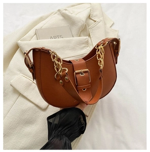 Detail of brown crescent bag with chunky gold chain and adjustable leather strap
