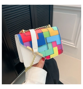 Detail of white chain bag featuring colorful geometric patterns and gold metal strap