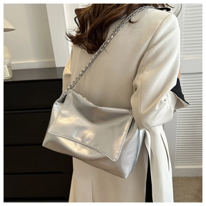Detailed view of silver metallic leather handbag with chain strap and fashion embossing