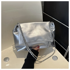 Detailed shot of silver wrinkled leather texture and dual chain straps on a tote bag