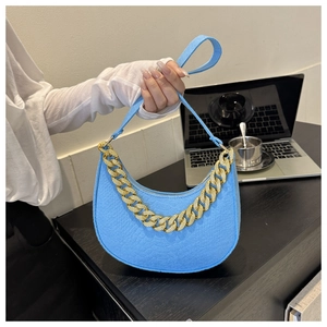 Detail of light blue hobo bag featuring embossed texture and decorative chunky gold chain