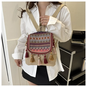 Close-up of bohemian woven backpack featuring colorful tassels and ethnic geometric patterns