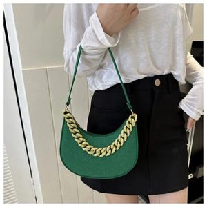 Detail of emerald green moon bag with lychee texture and bold golden metal chain