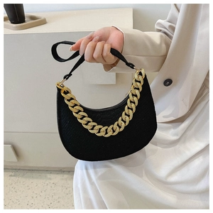 Detail of black crescent shoulder bag with chunky gold chain and textured fabric