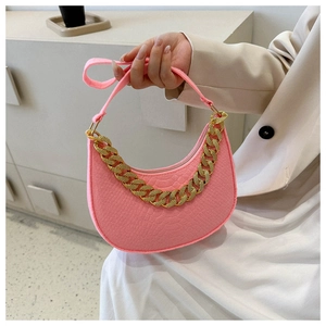 Close-up of pink embossed leather half-moon bag with decorative chunky gold chain