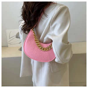Detail of bright pink embossed leather underarm bag with thick gold chain strap