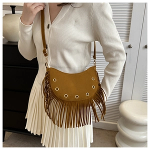 Détail du sac à bandoulière en daim marron à franges et œillets dorés sur mannequin