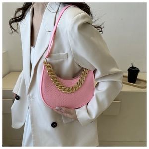 Detailed macro view of pink crocodile pattern half-moon bag with golden chain accent