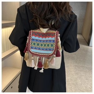Détail de sac à dos bohème avec motifs géométriques vibrants et glands colorés
