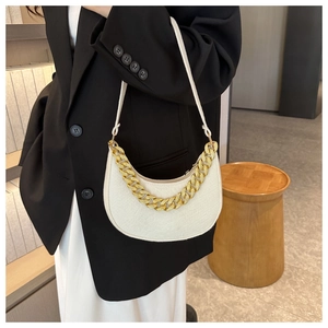 Detail of a creamy white crescent bag with a chunky gold chain and wool fabric texture