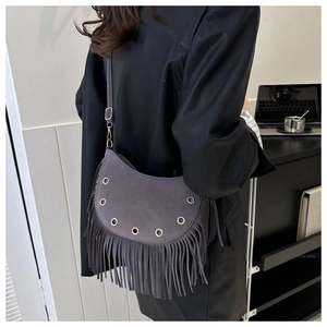 Détail du sac bandoulière gris à pompons, texture daim, longues franges et œillet en métal