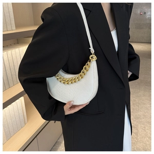 Macro view of white croc-embossed crescent bag featuring luxury gold chain strap detail