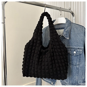 Détail de la texture bulle noire sur un sac cabas froncé élégant avec large bandoulière