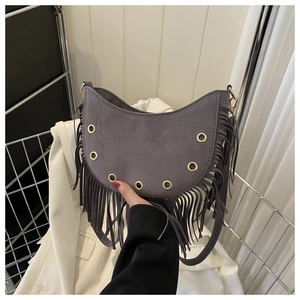 Détails du sac demi-lune en daim gris avec œillets métalliques et longues franges