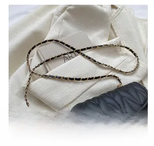 Detail der schwarzen Stepptasche mit goldenem Metallschloss und Leder-Kettenriemen