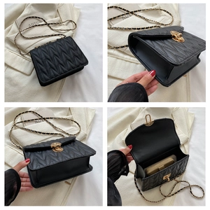 Detailansicht der schwarzen Stepptasche mit goldenem Drehverschluss und Kette