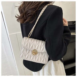 Nahaufnahme einer weißen gesteppten Ketten-Schultertasche mit goldener Hardware