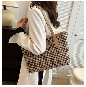 Detail of classic brown houndstooth tote bag with premium leather handles and metal rivets