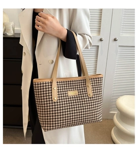 Close-up of classic houndstooth pattern fabric with elegant beige leather handles on tote