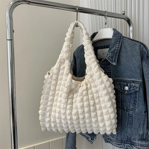 Sac à bandoulière blanc à texture gaufrée en tissu bouffant sur fond style de vie
