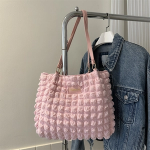 Pink quilted shoulder bag with bubble texture and gold fashion tag for women
