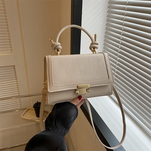Beige crocodile embossed square handbag with golden clasp and knotted handle detail