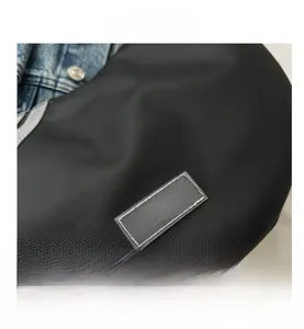 Close-up of durable black nylon texture with Fashion label on the shoulder bag
