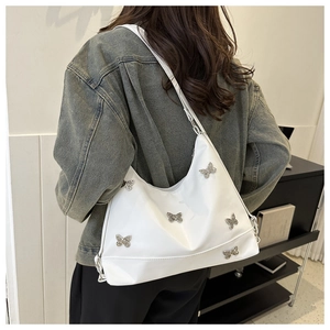 Gros plan du sac fourre-tout en cuir blanc orné de papillons argentés élégants