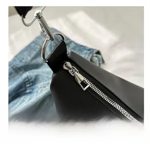 Detail of high-density nylon crossbody bag featuring silver metal zipper and woven strap