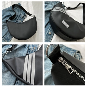 Detail view of black nylon dumpling bag with fashion patch and silver hardware