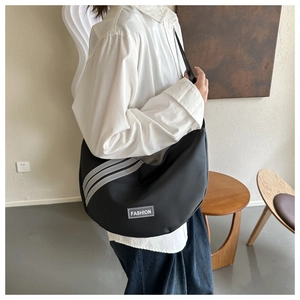 Detail of black nylon crescent crossbody bag with grey stripes and fashion label
