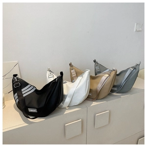 Macro shot of nylon dumpling bags in black, white, khaki and grey with fashion labels