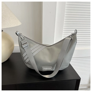 Detail of grey nylon crescent bag with three decorative stripes and Fashion label