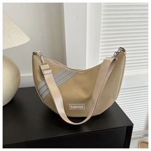 Detail of khaki crescent crossbody nylon bag with fashion label and textured strap