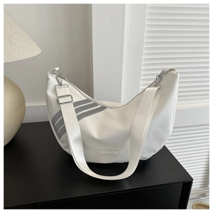 Detail of white nylon hobo bag with grey diagonal stripes and a fashion label on black table
